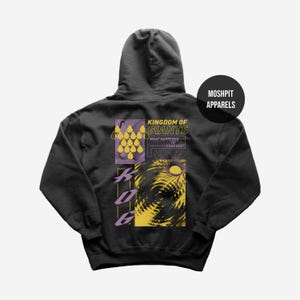 Op de afbeelding: Donkergrijze hoodie met een grafisch ontwerp op de achterkant. Het ontwerp bevat de tekst "Kingdom of Giants" en "What Happened to Forever?" in geel en wit. De hoodie heeft ook een afbeelding van een zon en andere abstracte vormen.