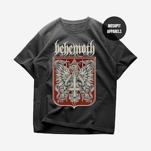 May include: Dark gray t-shirt featuring a red and white graphic with the word "behemoth" in a gothic font. The graphic includes wings, snakes, and a cross. The shirt has a round neck and short sleeves. The brand name "Moshpit Apparels" is also visible.