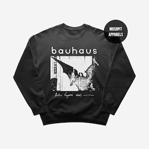 May include: Dark gray sweatshirt featuring the band name "bauhaus" in white block letters above a black and white graphic. The graphic includes a stylized image and the text "Bela Lugosi's dead".