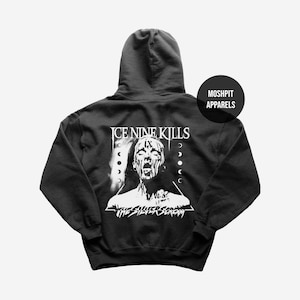 May include: Black hooded sweatshirt with a white graphic on the back. The graphic features the text "ICE NINE KILLS" above a screaming face and the text "THE SILVER SCREAM" below. A circular logo with the text "MOSHPIT APPARELS" is on the upper right.
