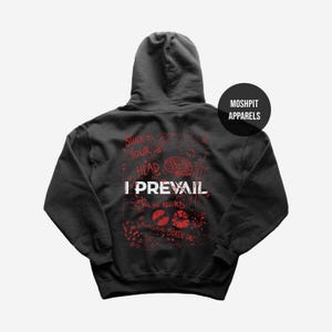 Puede incluir: Sudadera con capucha gris oscuro con el texto "I Prevail" en blanco, y gráficos y texto en rojo, incluyendo "Stuck in Your Head" y "For the Record". La sudadera tiene capucha y un logo de "Moshpit Apparels".