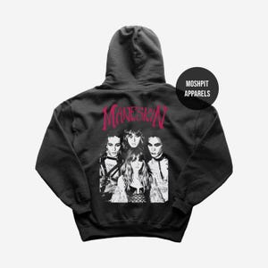 May include: Black hoodie featuring a grayscale image of a band and the word "MANESKIN" in pink script across the back. The hoodie also has the text "MOSHPIT APPARELS" in a black circle.