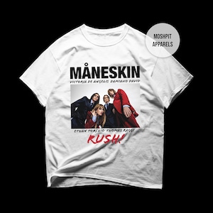 May include: White t-shirt featuring the band Måneskin. The shirt displays the band's name in bold black letters above a photo of the band members. Below the photo, the word "RUSH!" is written in red.