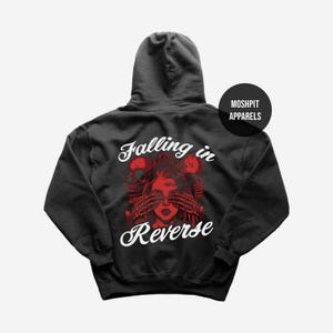 May include: Dark grey hoodie with a red graphic of a woman with hands over her eyes, skulls, and the words "Falling in Reverse" in white script. The hoodie has a hood and a "Moshpit Apparels" logo.