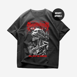 Puede incluir: Camiseta gris oscuro con un gráfico detallado de calavera estilizada en blanco y rojo, y el texto "FALL INTO THE DARKSIDE". La camiseta también incluye el texto "MOSHPIT APPARELS" en un logotipo circular. El diseño está impreso en una camiseta de manga corta.