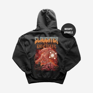 May include: Dark gray hooded sweatshirt with a graphic design on the back. The design features a monster with a glowing orb, surrounded by other creatures and the text "SLAUGHTER TO PREVAIL". The brand name "MOSHPIT APPARELS" is on the upper right.