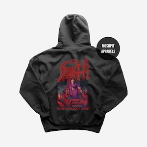 Może przedstawiać: Ciemnoszara bluza z kapturem z czerwoną grafiką przedstawiającą szkielet i inne postacie, z napisem "DEATH" powyżej i "SCREAM BLOODY GORE" poniżej. Bluza ma kaptur i okrągłą czarną etykietę z napisem "MOSHPIT APPARELS".