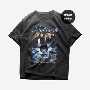 May include: Dark gray t-shirt featuring the band Nightwish. The shirt has a graphic design with the band's name in a blue, stylized font, and a skull design. The text "Dark Passion Play" is below the skull. The shirt is from Moshpit Apparels.