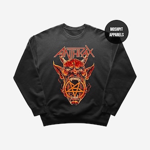 May include: Black Anthrax sweatshirt with a red and yellow devil graphic and a pentagram. The band's name is in red block letters above the devil's head. The sweatshirt has a crew neck and long sleeves. The brand name "Moshpit Apparels" is in a black circle.