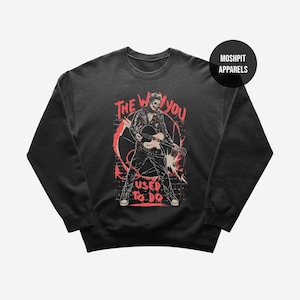 Puede incluir: Sudadera negra de cuello redondo con un gráfico de una persona tocando la guitarra, con una cara de calavera, y el texto "THE WAY YOU USED TO DO" en rojo. La sudadera tiene un cuello redondo y acanalado.