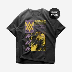 Op de afbeelding: Donkergrijs t-shirt met een grafisch ontwerp. Het ontwerp bevat de tekst "KINGDOM OF GIANTS" en de vraag "WHAT HAPPENED TO FOREVER?". Het bevat gele en paarse geometrische vormen en een wervelend geel patroon.