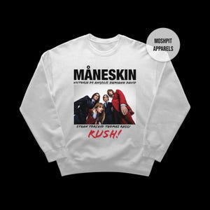 May include: White sweatshirt featuring the band Måneskin with the text "MÅNESKIN" above a photo of the band members. The names of the band members are listed below the photo, and the word "RUSH!" is in red at the bottom.