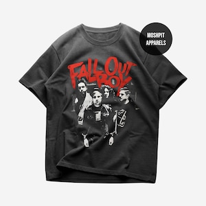 May include: Dark grey t-shirt with a band photo and the words "Fall Out Boy" in red, stylized text. The shirt also has the text "Moshpit Apparels" in a black circle. The t-shirt is made of a soft material.