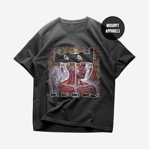Pode incluir: T-shirt cinza escuro com um design gráfico com o logotipo da banda e a palavra "Lateralus". O design inclui uma ilustração anatómica detalhada em vermelho e branco, com um fundo psicodélico. A t-shirt tem mangas curtas e gola redonda.