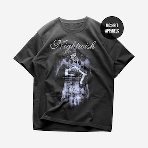 May include: Dark gray t-shirt featuring the band name "Nightwish" in a cursive font above a graphic. The graphic depicts a figure resting on a tombstone with the word "ONCE" visible. The shirt also has a "Moshpit Apparels" logo.