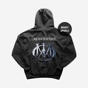 May include: A dark grey hooded sweatshirt with the band name "Dream Theater" in white lettering above a silver and blue logo. The sweatshirt has a drawstring hood and a front pocket. The brand "Moshpit Apparels" is also visible.