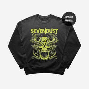 May include: Black crewneck sweatshirt featuring a neon green skull graphic with snakes, wings, and the band name "SEVENDUST" in distressed lettering. The design includes crossbones and a logo. "MOSHPIT APPARELS" is printed on a black circle.