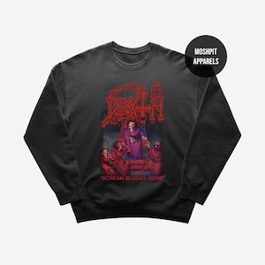 Może przedstawiać: Ciemnoszara bluza z czerwonym nadrukiem z napisem "DEATH" i ilustracją szkieletu. Pod grafiką znajduje się napis "SCREAM BLOODY GORE". Nazwa marki "MOSHPIT APPARELS" znajduje się w czarnym okręgu.