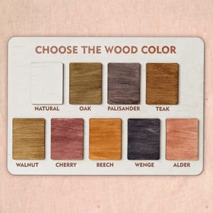 Puede incluir: Un tablero rectangular de madera con el texto CHOOSE THE WOOD COLOR y nueve muestras rectangulares de madera etiquetadas como Natural, Oak, Palisander, Teak, Walnut, Cherry, Beech, Wenge y Alder, cada una con un grano y tono de color distintos.