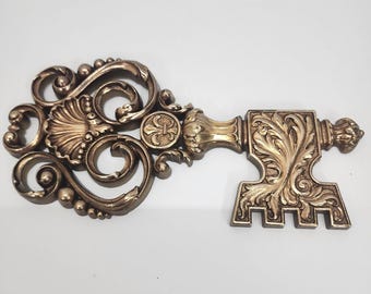 Placa de parede vintage Syroco 455 com chave esqueleto dourada ornamentada, estilo Hollywood Regency, EUA.