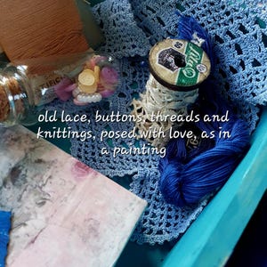 Peut inclure: Un assortiment de fournitures de couture, comprenant des bobines de fil, de la dentelle, des boutons et du crochet bleu. Le texte "old lace, buttons, threads and knittings, posed with love, as in a painting" est inclus.
