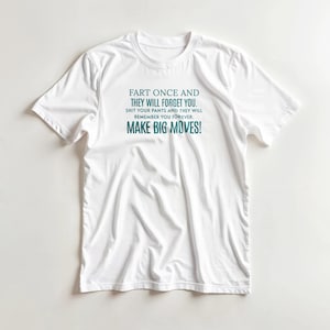 May include: White t-shirt featuring the teal text: "FART ONCE AND THEY WILL FORGET YOU. SHIT YOUR PANTS AND THEY WILL REMEMBER YOU FOREVER. MAKE BIG MOVES!" The shirt has a crew neck and short sleeves.