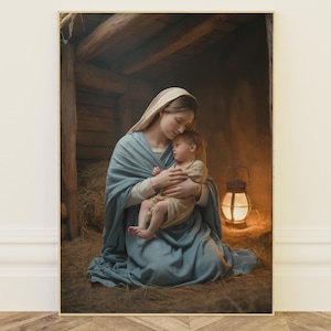 May include: A framed print depicts a tender scene of a mother cradling a child. The mother is draped in a blue robe and veil, while the child is wrapped in a cream-colored cloth. A lantern casts a warm glow in the background, illuminating a rustic wooden structure.