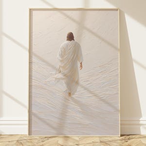 Può includere: Stampa artistica incorniciata raffigurante una figura in una veste bianca che si allontana. L'opera d'arte ha una tavolozza di colori neutri con uno sfondo strutturato. La cornice è di colore legno chiaro e l'opera è esposta contro un muro bianco.