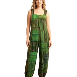May include: Green patchwork jumpsuit with a square neckline and wide straps. The jumpsuit features a mix of vertical and horizontal striped patterns in shades of green and black. The pants have a relaxed, harem-style fit.