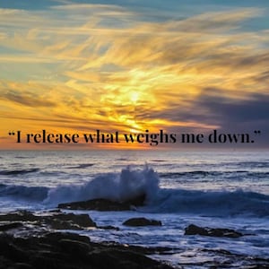 May include: A scenic image of a sunset over the ocean. The sky is a mix of blue, orange, and yellow hues, with the text "I release what weighs me down." The waves crash against the dark rocks in the foreground.
