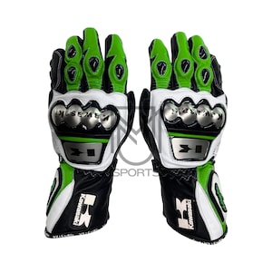 Puede incluir: Un par de guantes de moto negros, blancos y verdes. Los guantes presentan un logotipo y la marca Kawasaki. Los nudillos están protegidos por una armadura plateada. Los guantes tienen un diseño deportivo con detalles en verde y son de cuero.