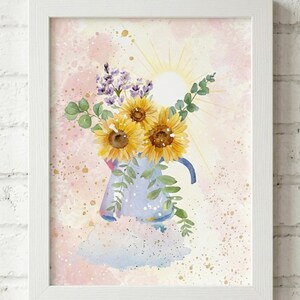 Può includere: Stampa artistica ad acquerello di girasoli e fiori viola in un annaffiatoio blu. L'opera d'arte è ambientata su uno sfondo rosa e giallo con un'illustrazione del sole. La stampa è incorniciata in una cornice bianca.