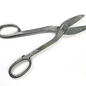 May include: A pair of vintage metal shears with a silver finish. The shears have a black label that reads "D1 S51M".