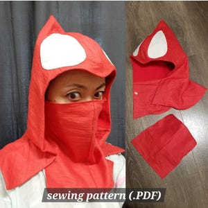 Puede incluir: Capucha roja con detalles blancos en forma de ojo, una cobertura facial a juego y una pieza separada. El texto "sewing pattern (.PDF)" es visible en la parte inferior. Es probable que sea un accesorio de disfraz o cosplay.
