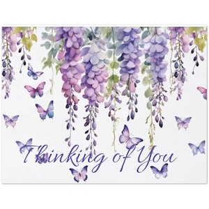 以下が含まれることがあります： 紫色の藤と蝶の水彩イラストが描かれた白いカード。「Thinking of You」というフレーズがカードの下部に筆記体フォントで書かれています。藤と蝶は紫とピンクの色合いです。