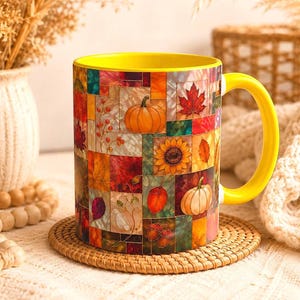 May include: A ceramic mug with a bright yellow interior and handle, featuring a colorful stained-glass style pattern of autumn leaves, pumpkins, sunflowers, and acorns. The mug is labeled as 11oz, showcasing a vibrant seasonal design.