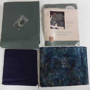 May include: An assortment of sewing project materials, including a green fabric, a navy blue fabric, and a patterned blue fabric. A package of buttons and a project pack labeled "Blue Reef Java Jacket" are also present. The items are arranged on a white surface.