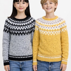 Puede incluir: Dos niños con suéteres de punto. Uno es gris con un patrón geométrico en blanco y negro, el otro es amarillo con un patrón geométrico en blanco y naranja. Ambos tienen mangas largas y se combinan con vaqueros azules.
