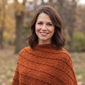 May include: A rust-colored knitted poncho featuring a textured, ribbed pattern with horizontal lines. The garment has a high neckline and a loose, draped fit that covers the shoulders and upper torso, crafted from a thick, warm yarn material.