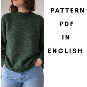 May include: A dark green long-sleeve knit sweater with a ribbed mock neck, cuffs, and hem, paired with light blue denim jeans. The text PATTERN PDF IN ENGLISH is displayed in black capital letters on the right side of the image.