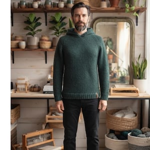 Peut inclure: Un pull à capuche vert forêt foncé à manches longues avec un ourlet et des poignets côtelés, porté avec un pantalon noir uni. Le pull présente une maille texturée et une capuche, offrant un vêtement simple et fonctionnel au quotidien.