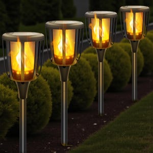 May include: Four solar-powered garden torches with a realistic flame effect. The torches have a dark bronze finish and are arranged in a row along a garden bed. The flame effect is a warm yellow-orange colour, creating a welcoming ambience.