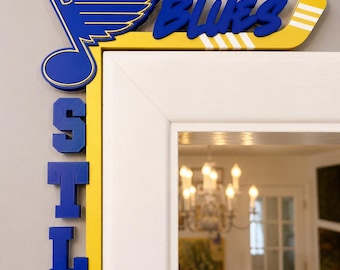 May include: A yellow and blue wooden door corner sign featuring the St. Louis Blues hockey logo, the word BLUES in blue script, and the letters STL stacked vertically in blue block font, designed to fit around the top corner of a door frame.