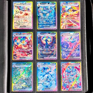 Puede incluir: Nueve cartas coleccionables de Pokémon coloridas en una carpeta. Las cartas presentan varios personajes Pokémon con ilustraciones y texto vibrantes. Las cartas están en fundas protectoras, con un borde amarillo y un borde rosa.