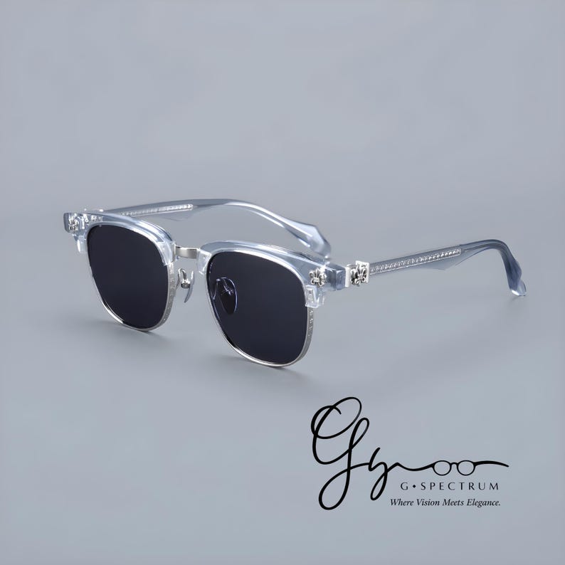 May include: Clear-framed sunglasses with dark lenses. The sunglasses have a silver metal bridge and decorative accents on the temples. The temples are embellished with small, clear stones. The image includes the text "G Spectrum" and "Where Vision Meets Elegance."