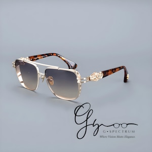 May include: Gold-coloured sunglasses with gradient lenses. The frames have a double bridge and decorative accents on the temples. The arms feature a tortoiseshell pattern. The logo "G Spectrum Where Vision Meets Elegance" is in the bottom right corner.