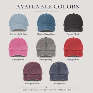 May include: A collection of eight baseball caps in various colors labeled AVAILABLE COLORS. The caps include denim light blue, denim deep blue, denim black, vintage pink, vintage grey, vintage red, vintage maroon, and vintage navy.