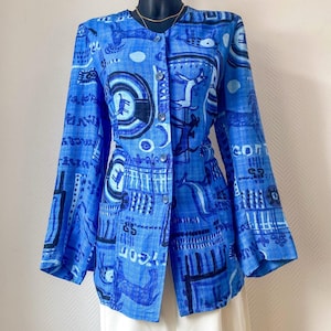 Peut inclure: Une chemise boutonnée bleue avec un motif unique de formes abstraites et de texte. La chemise à manches longues est présentée sur un mannequin. La chemise est associée à un pantalon blanc.