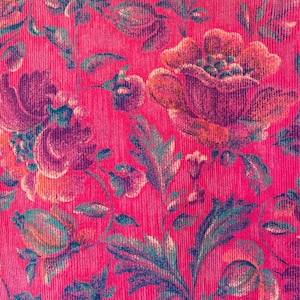 May include: A vibrant hot pink corduroy fabric featuring a repeating floral pattern. The design showcases large, blooming flowers and intricate leafy stems in shades of deep purple, dark green, and muted orange, set against the textured ribbed surface.