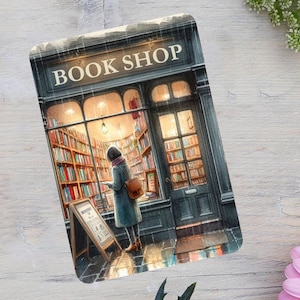 May include: Watercolor illustration of a book shop with the text "BOOK SHOP" above the entrance. A person is standing inside the shop, looking at books on the shelves. A-frame sign in front of the shop.
